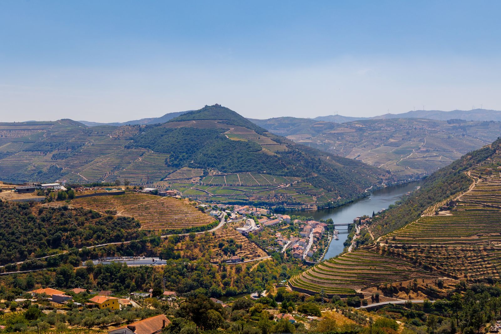 Terraced vineyards and a riverside village in the Douro Valley, a popular river cruise whose cost depends on the season