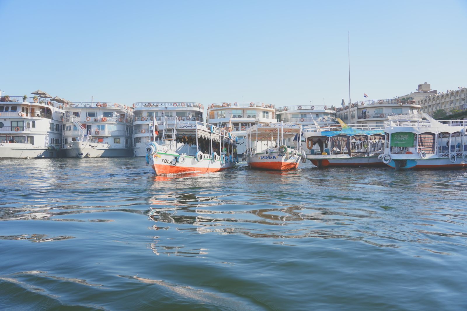 Several multi-deck river boats moored side by side at a quay